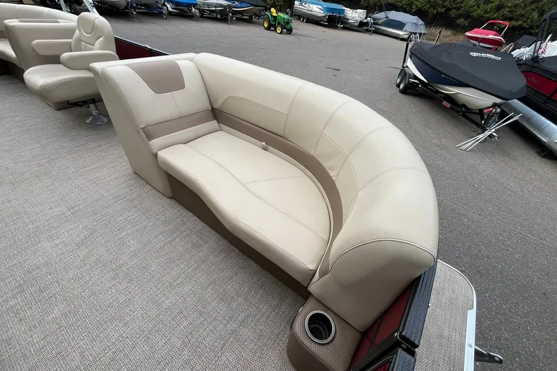 Slide: The Image of 2017 Crest I 220 L pontoon boat with beige seating and cup holder, parked outdoors. - 9