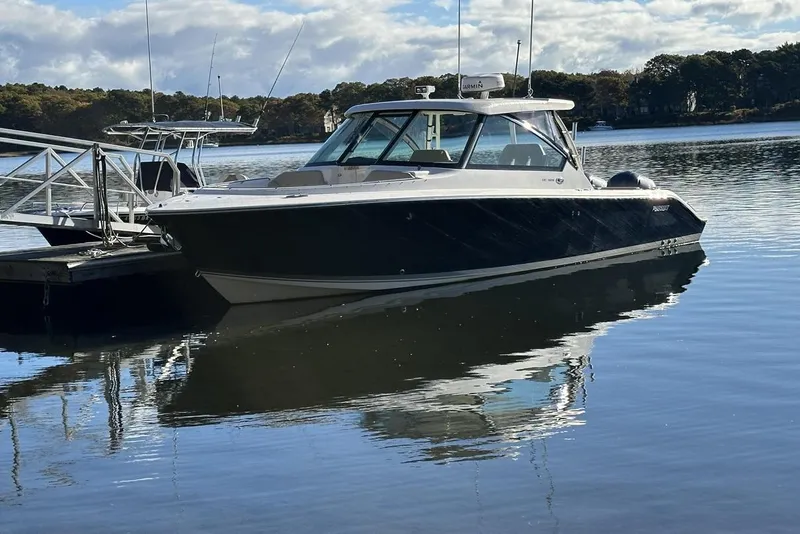 The Image of 2016 Pursuit DC 325 Dual Console boat docked on calm water. - 0