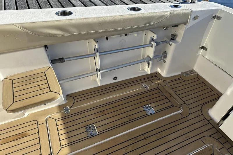 Slide: The Image of 2016 Pursuit DC 325 Dual Console boat deck with wood finish and rod holders. - 11