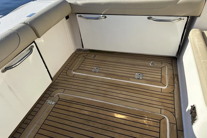 Slide: The Image of 2016 Pursuit DC 325 Dual Console boat interior with teak flooring and cushioned seating. - 12