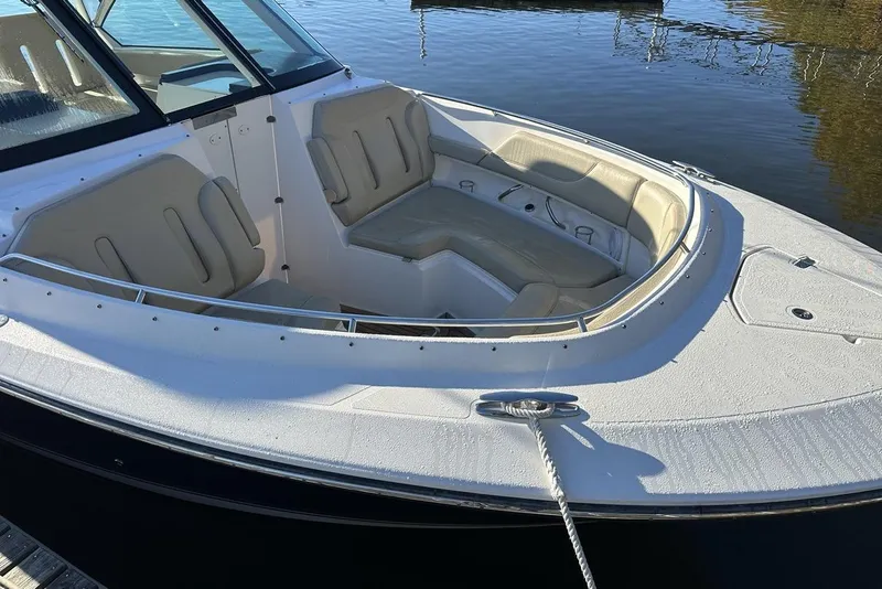 Slide: The Image of 2016 Pursuit DC 325 Dual Console boat with spacious seating, docked on calm water. - 2