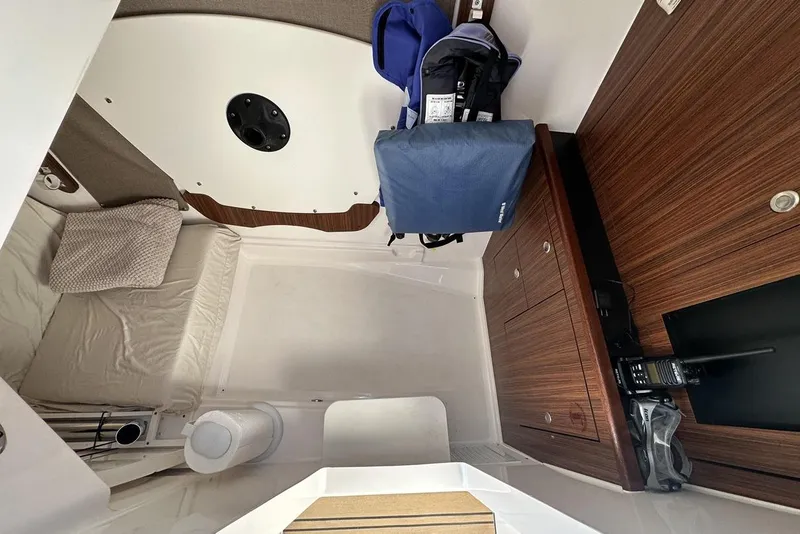 Slide: The Image of 2016 Pursuit DC 325 Dual Console cabin interior with wood cabinetry and seating area. - 22