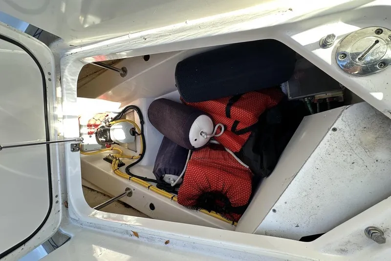 Slide: The Image of Storage compartment of 2016 Pursuit DC 325 Dual Console boat with safety equipment. - 31