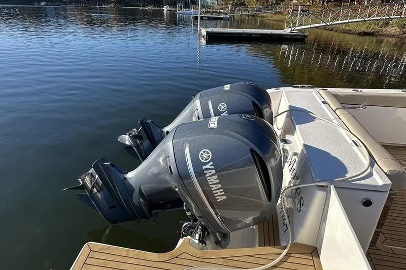 Slide: The Image of 2016 Pursuit DC 325 Dual Console with twin Yamaha outboard engines on a calm lake. - 6