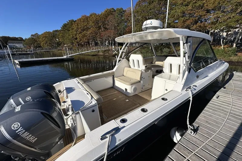 Slide: The Image of 2016 Pursuit DC 325 Dual Console boat docked, featuring Yamaha engines and spacious seating. - 7