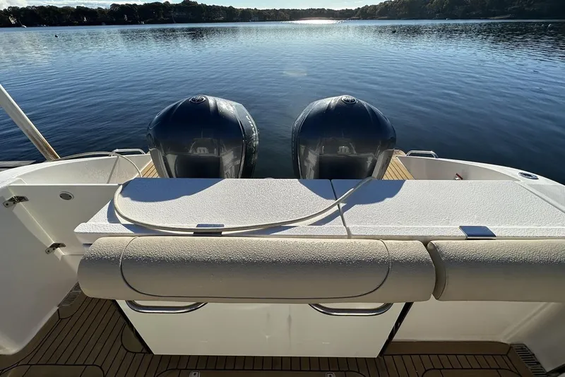 Slide: The Image of 2016 Pursuit DC 325 Dual Console boat with twin engines on a serene lake. - 8