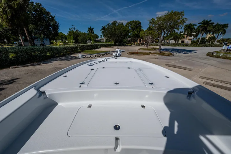 Slide: The Image of 2026 Yellowfin 24 Bay CE boat deck, parked outdoors under clear blue sky. - 12