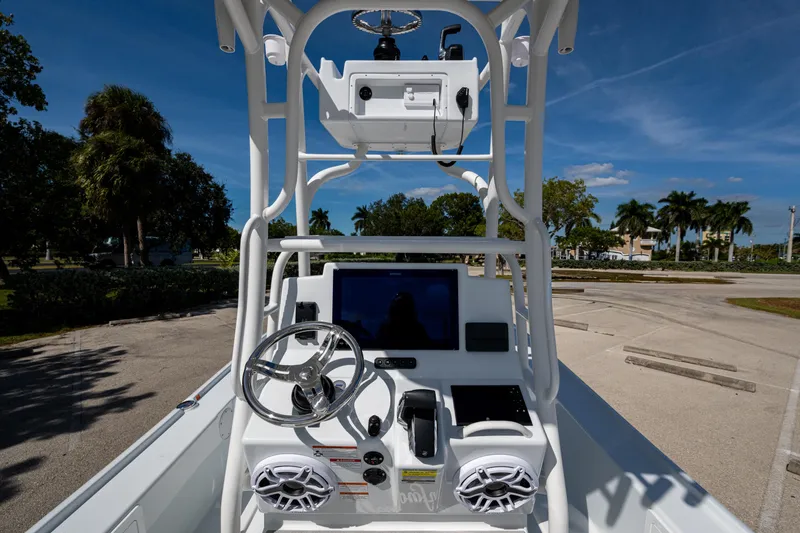Slide: The Image of 2026 Yellowfin 24 Bay CE boat console with steering wheel and electronics under clear blue sky. - 2