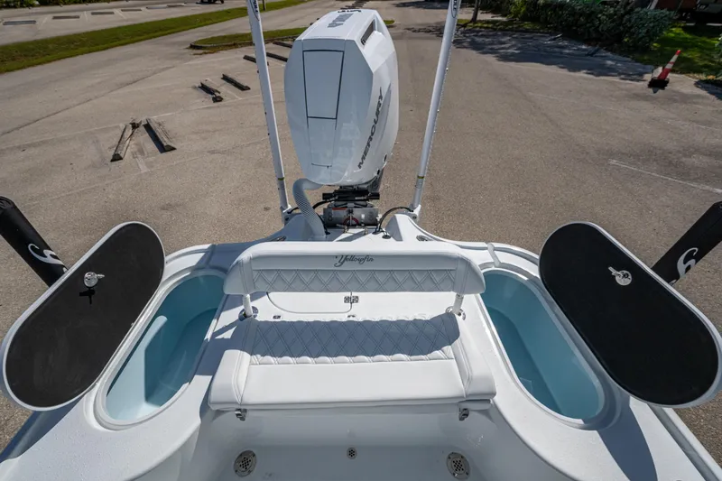 Slide: The Image of 2026 Yellowfin 24 Bay CE boat with Mercury engine, featuring dual livewells and cushioned seating. - 22