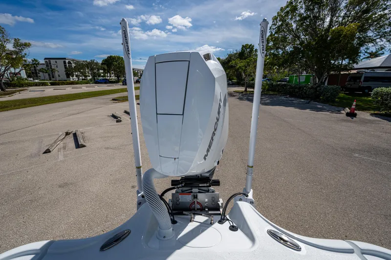 Slide: The Image of 2026 Yellowfin 24 Bay CE boat with Mercury engine, parked outdoors under a clear sky. - 26
