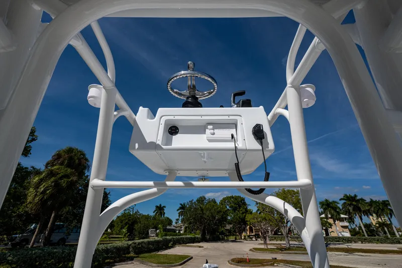 Slide: The Image of 2026 Yellowfin 24 Bay CE boat console with steering wheel, under clear blue sky. - 8