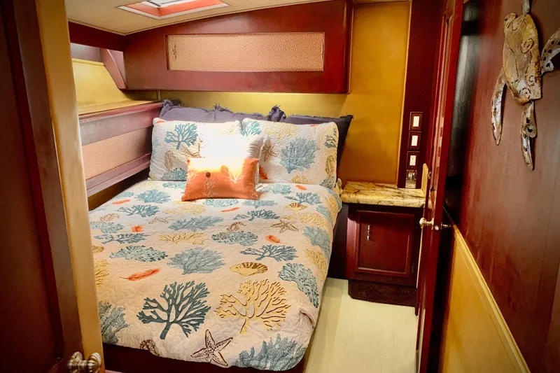 Slide: The Image of Cozy bedroom in 1984 Egg Harbor 48' Flybridge with nautical-themed bedding and warm wood accents. - 11
