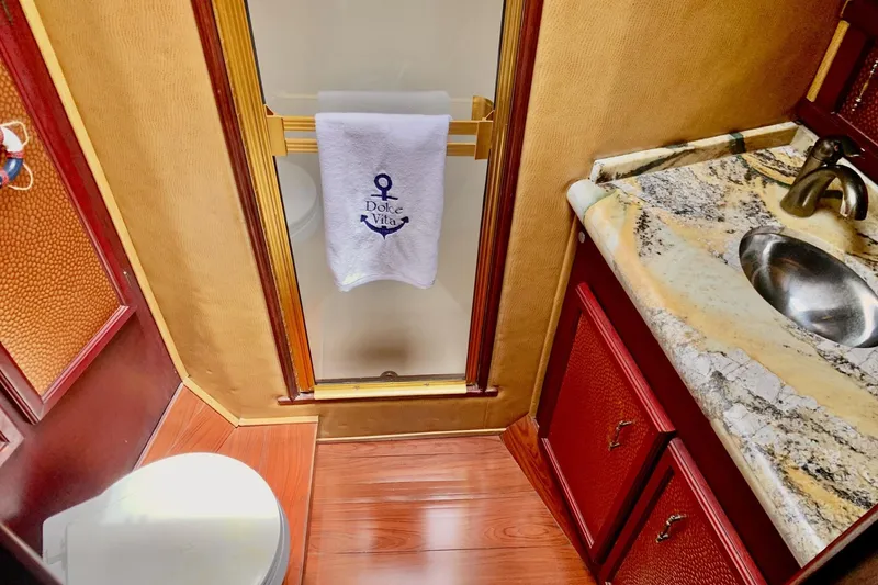 Slide: The Image of Luxurious bathroom in 1984 Egg Harbor 48' Flybridge yacht with marble countertop and elegant fixtures. - 16