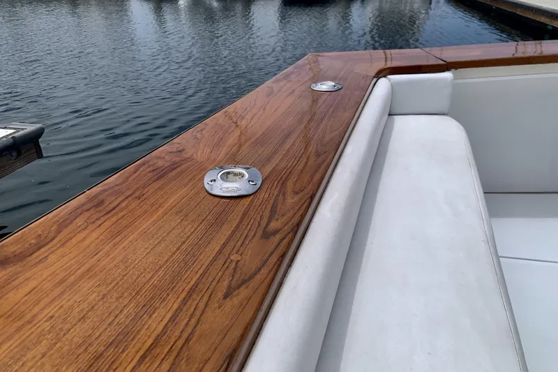 Slide: The Image of 1984 Egg Harbor 48' Flybridge with polished wood and white seating by the water. - 17