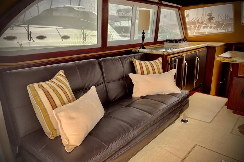 Slide: The Image of Interior of 1984 Egg Harbor 48' Flybridge with leather sofa and striped cushions. - 6