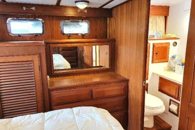 Slide: The Image of 1998 DeFever 44 Sundeck Trawler interior with wood paneling and cozy cabin amenities. - 10