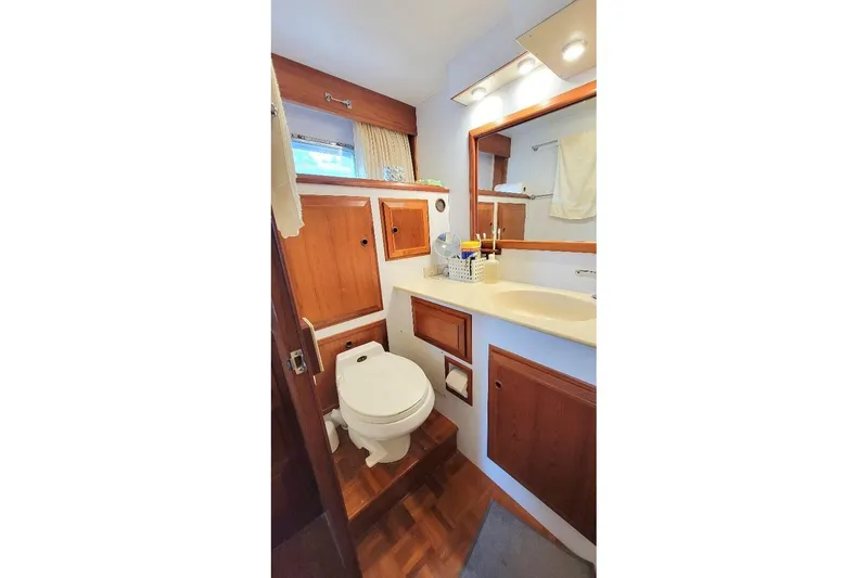 Slide: The Image of Bathroom interior of 1998 DeFever 44 Sundeck Trawler with wooden cabinetry and modern fixtures. - 13