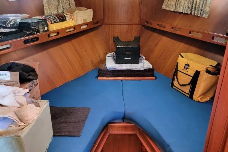 Slide: The Image of Cozy cabin interior of 1998 DeFever 44 Sundeck Trawler with blue cushions and storage. - 16