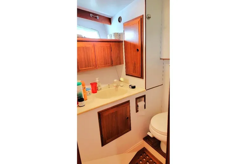 Slide: The Image of Bathroom interior of 1998 DeFever 44 Sundeck Trawler with wooden cabinets and sink. - 17