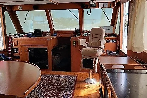 Slide: The Image of 1998 DeFever 44 Sundeck Trawler interior with helm, wooden furnishings, and nautical decor. - 2