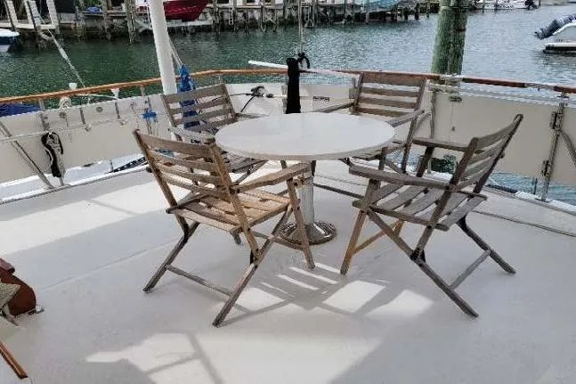 Slide: The Image of Outdoor seating on 1998 DeFever 44 Sundeck Trawler with wooden chairs and round table. - 20