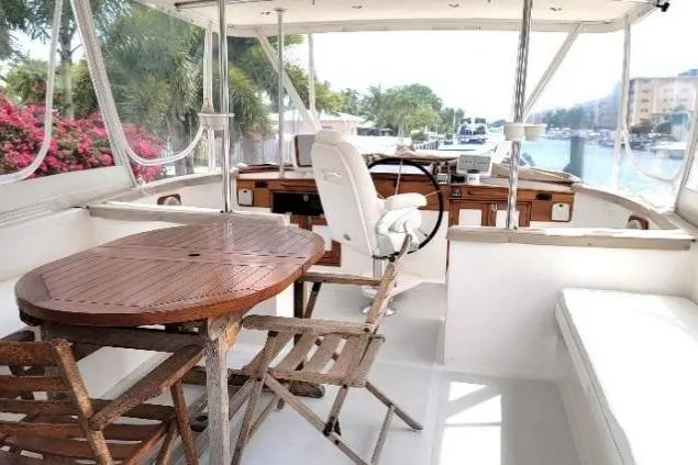 Slide: The Image of 1998 DeFever 44 Sundeck Trawler interior with wooden table, chairs, and helm station. - 21