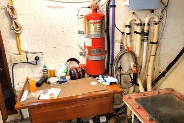Slide: The Image of Engine room of 1998 DeFever 44 Sundeck Trawler with fire extinguisher and maintenance tools. - 26