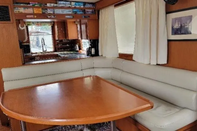 Slide: The Image of Interior of 1998 DeFever 44 Sundeck Trawler with cozy dining area and wooden table. - 3
