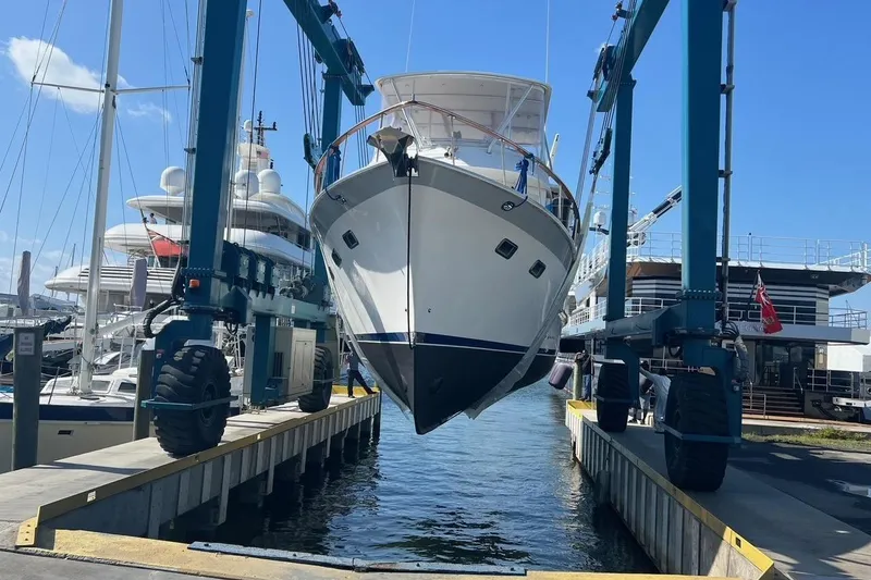 Slide: The Image of DeFever 44 Sundeck Trawler 1998 being lifted at a marina with blue sky. - 35