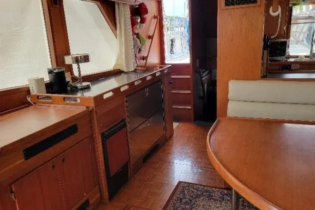 Slide: The Image of Interior of 1998 DeFever 44 Sundeck Trawler with wooden cabinetry and dining area. - 4
