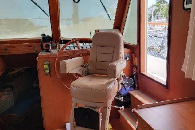 Slide: The Image of 1998 DeFever 44 Sundeck Trawler helm with captain's chair and wooden interior. - 5
