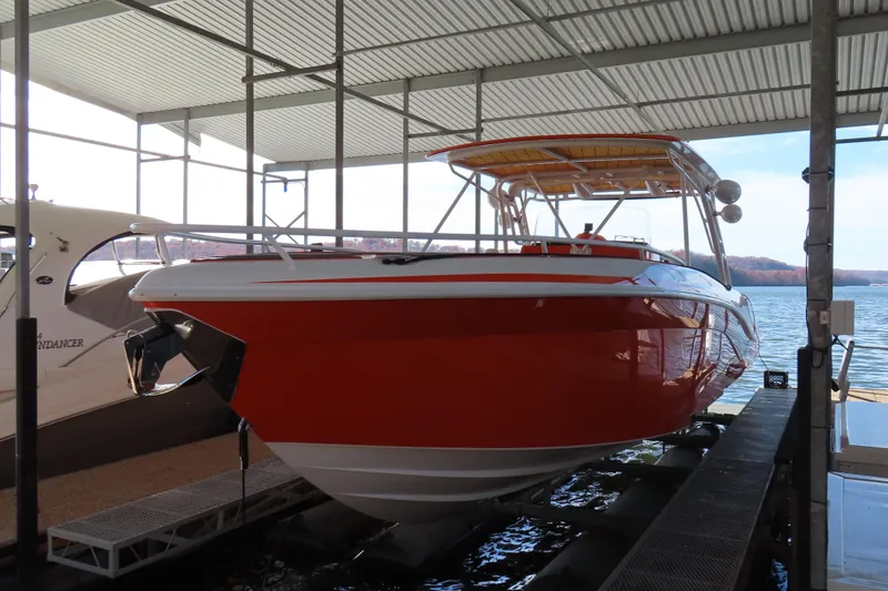 The Image of 2007 Deep Impact 36 boat in dock, vibrant red hull, under covered marina. - 0