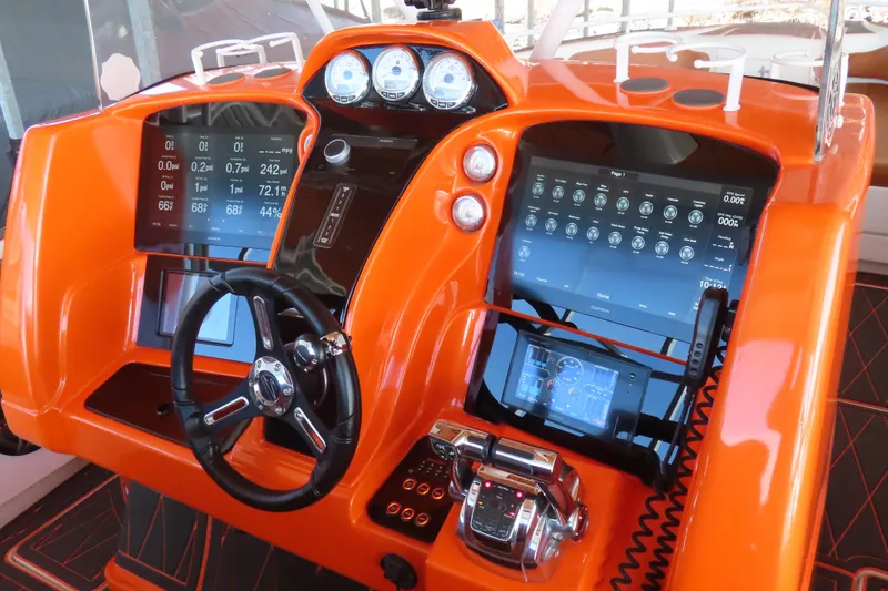 Slide: The Image of Orange dashboard of 2007 Deep Impact 36 boat with advanced digital controls and steering wheel. - 13
