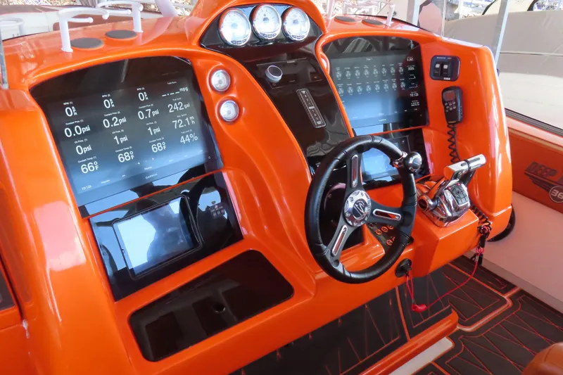 Slide: The Image of Orange dashboard of a 2007 Deep Impact 36 boat with modern controls and displays. - 14