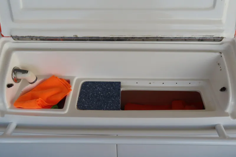 Slide: The Image of Open storage compartment in a 2007 Deep Impact 36 boat, featuring an orange cloth and faucet. - 26