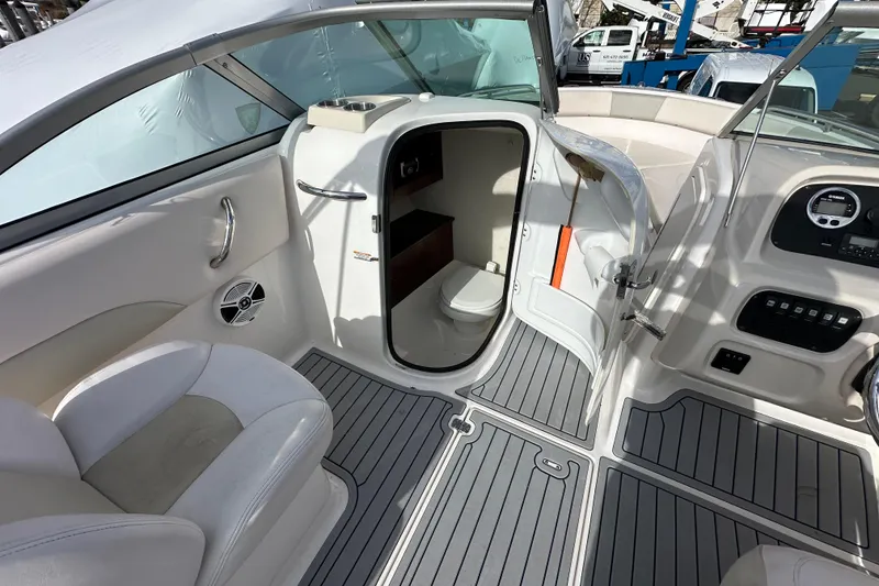 Slide: The Image of 2016 Robalo R227 Dual Console interior with seating, helm, and cabin door. - 11