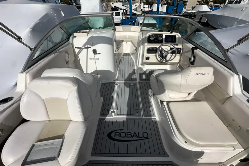 Slide: The Image of 2016 Robalo R227 Dual Console boat interior with white seating and steering wheel. - 14