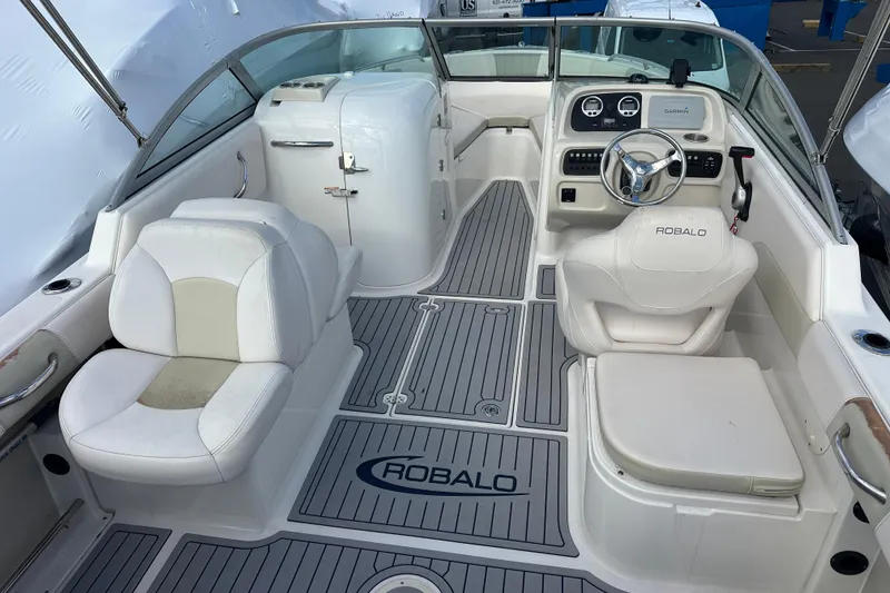 Slide: The Image of 2016 Robalo R227 Dual Console boat interior with white seating and modern dashboard. - 7