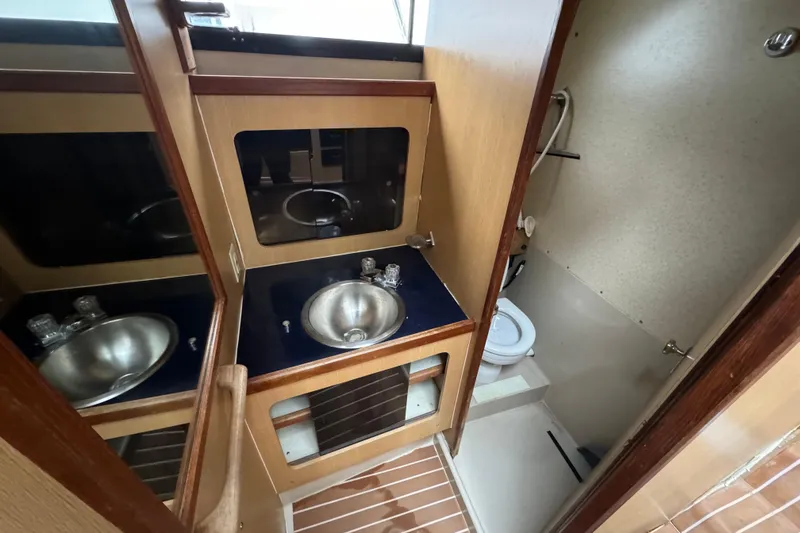 Slide: The Image of 1986 Stamas Flybridge Sedan bathroom with sink, mirror, and toilet. - 11