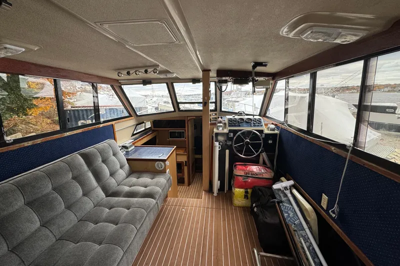 Slide: The Image of 1986 Stamas Flybridge Sedan interior with helm, seating, and nautical equipment. - 12