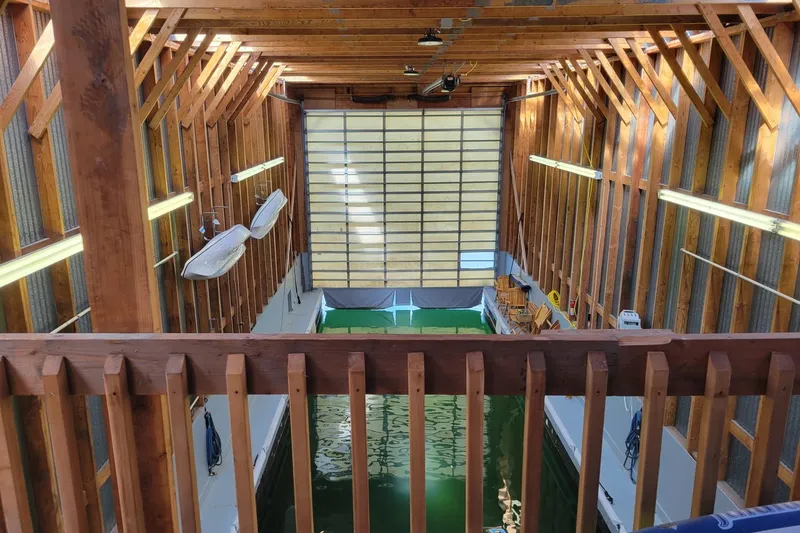 The Image of Interior of a wooden boathouse with water, built in 2005 by BoatHouse. - 1