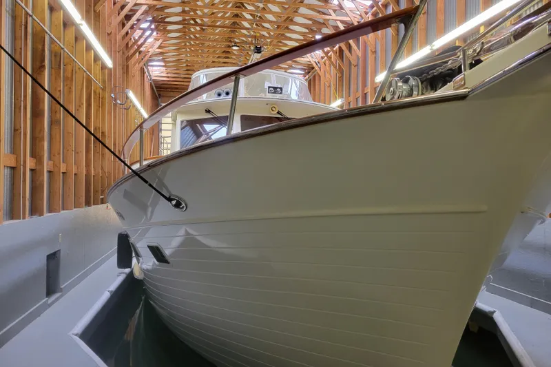 Slide: The Image of A 2005 BoatHouse model docked inside a wooden boathouse with exposed beams. - 10