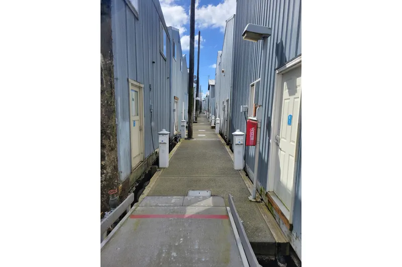 Slide: The Image of Narrow walkway between boathouses with blue sky, featuring BoatHouse model from 2005. - 7