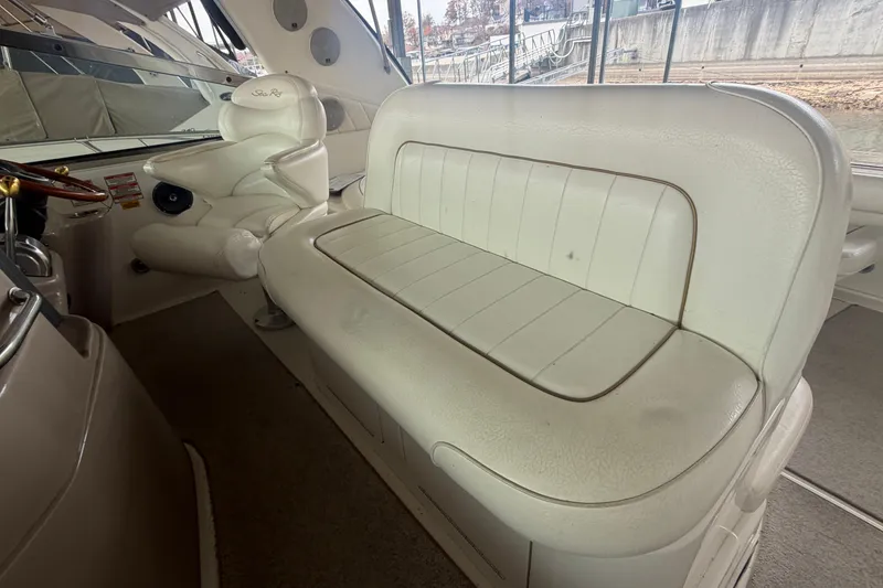 Slide: The Image of 1999 Sea Ray 400 Sundancer interior with white leather seating and helm chair. - 10