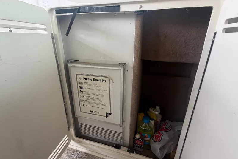 Slide: The Image of Open cabinet on 1999 Sea Ray 400 Sundancer with cleaning supplies and instructions. - 11