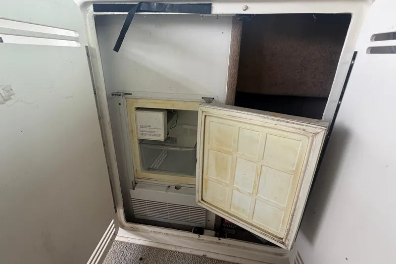 Slide: The Image of 1999 Sea Ray 400 Sundancer ice maker with open door, showing interior details. - 12