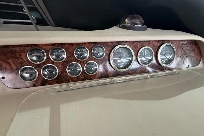 Slide: The Image of Dashboard of a 1999 Sea Ray 400 Sundancer with multiple gauges and wood paneling. - 16