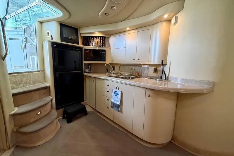 Slide: The Image of 1999 Sea Ray 400 Sundancer yacht interior kitchen with modern amenities and elegant design. - 20