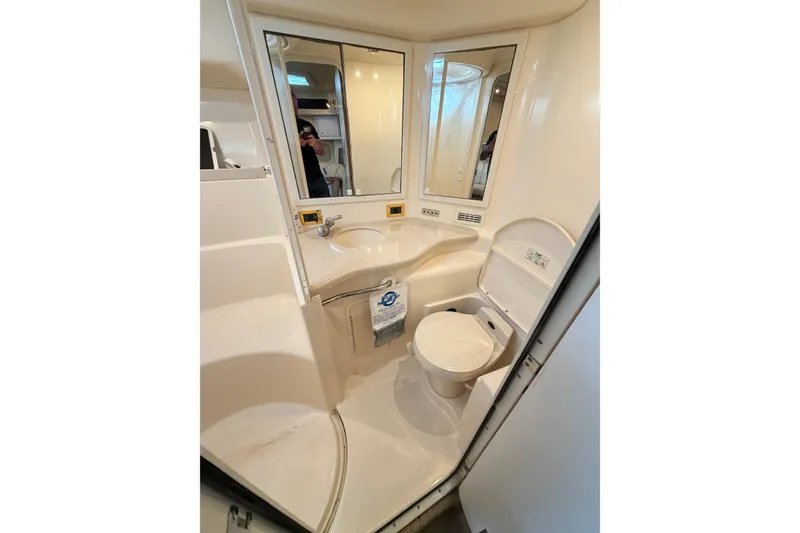 Slide: The Image of 1999 Sea Ray 400 Sundancer bathroom with sink, toilet, and mirrors. - 26