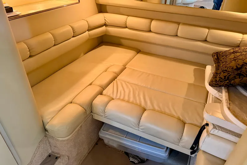 Slide: The Image of 1999 Sea Ray 400 Sundancer interior with beige leather seating and decorative pillow. - 29